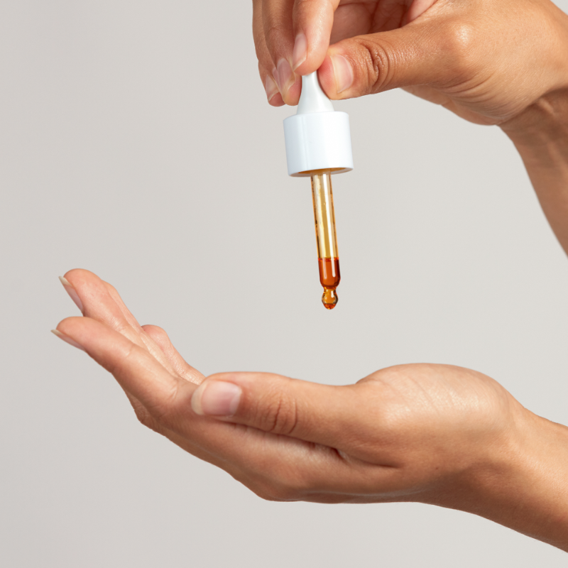 Γυναίκα που εφαρμόζει έλαιο αγριοτριανταφυλλιάς για φυσική λάμψη και ανάπλαση δέρματος